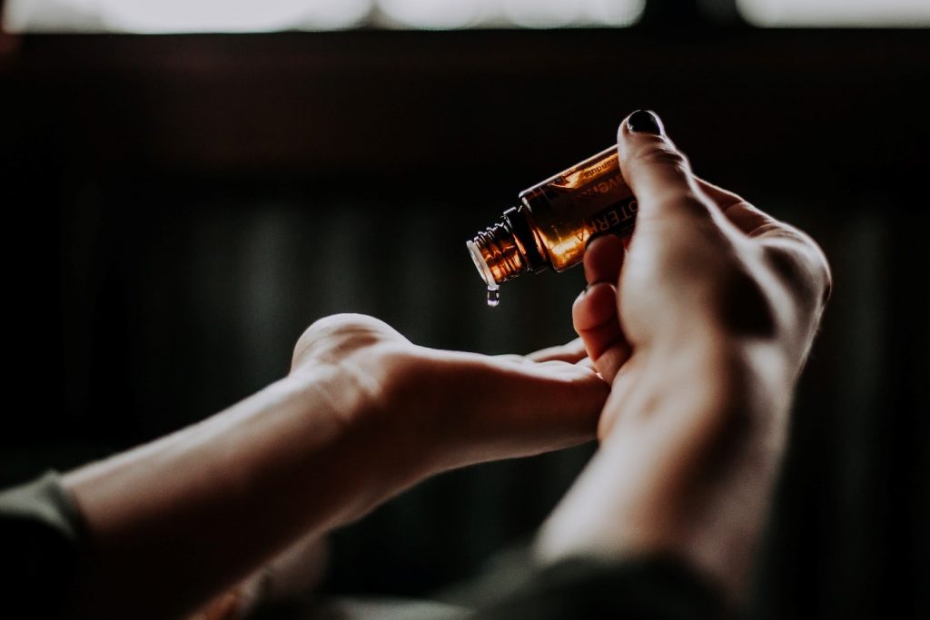 Stay at Home Organic Skin Care Routine 5 A close up of a hand and amber bottle