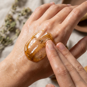 Hands applying a plant-based serum in a clean clinical skincare routine.